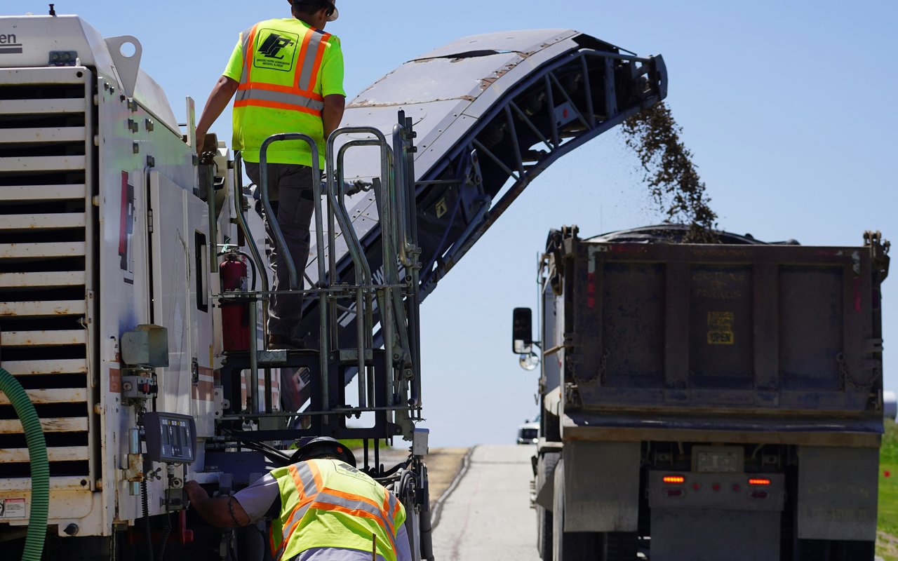 Milling machine loading reclaimed asphalt into a truck